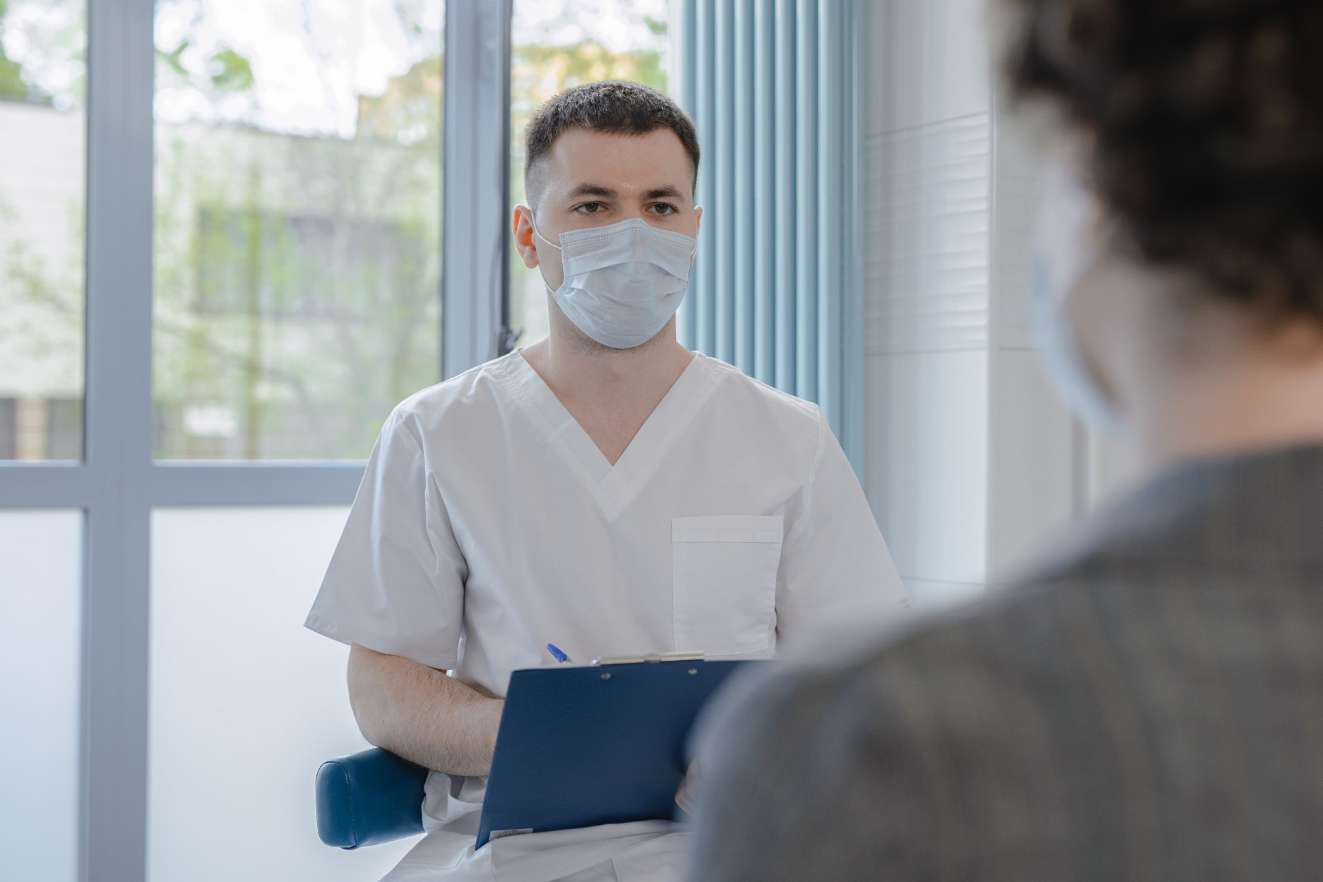 Clinician with clipboard during a follow-up consultation